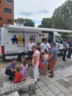 ludzie zgromadzeni przy mobilnym posterunku oraz policjanci