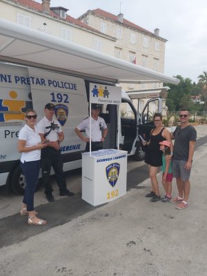 ludzie zgromadzeni przy mobilnym posterunku oraz policjanci