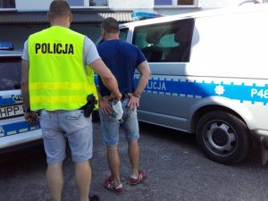 policjant prowadzi zatrzymanego mężczynę