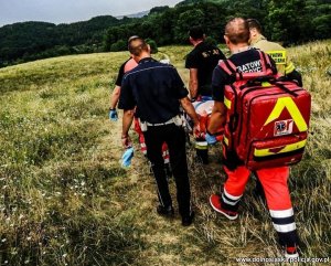 Policjanci i ratownicy niosą poszkodowanego mężczyznę