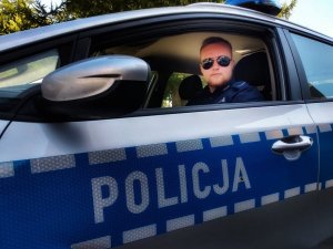 policjant siedzi w radiowozie policyjnym