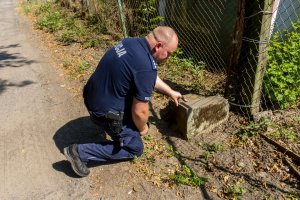 na zdjęciach widzimy policjantów, którzy przyjechali na miejsce zdarzenia oraz wykopane nagrobki