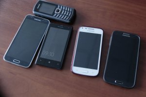 pięć telefonów komórkowych leżących na stole