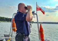 policjant na łodzi patrzy przez lornetkę