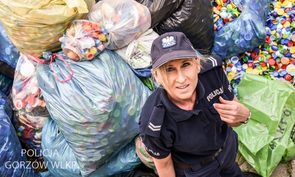 Gorzowska policjantka sierżant sztabowy Monika Brojecka w tle zebrane nakrętki w foliowych workach