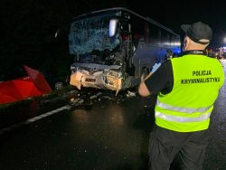 policjant stojący na drodze, w tle widać wypadek