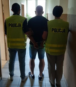 dwaj policjanci z zatrzymanym mężczyzną