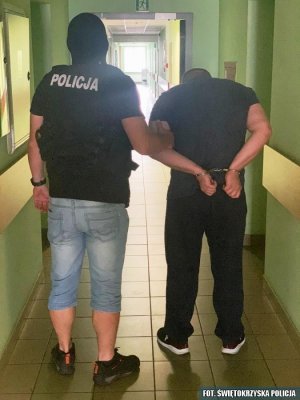 policjant prowadzi zatrzymanego mężczyznę