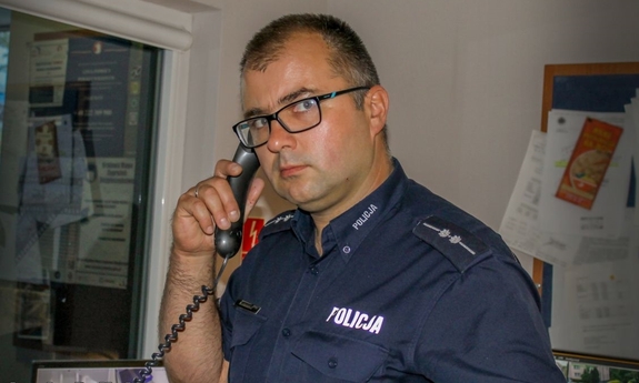 policjant rozmawia przez telefon