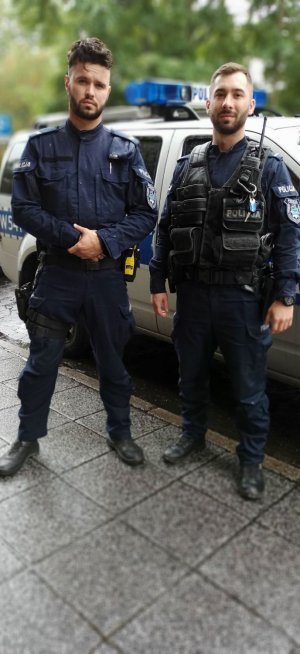 dwaj policjanci przed radiowozem