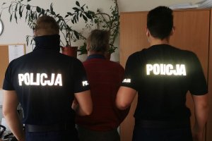 dwaj policjanci z zatrzymanym mężczyzną