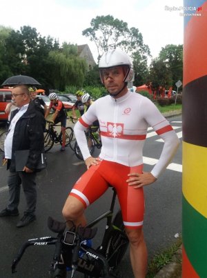 Mistrz Polski Piotr Ścigała w stroju kolarskim i z rowerem stoi na starcie