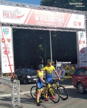 kobieta i mężczyzna w stroju kolarskim na rowerach pozują do zdjęcia obejmując się