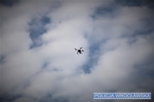 Na zdjęciu policyjny dron unoszący się nad niebem.