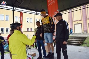 Na zdjęciach widzimy policjantów, którzy wzięli udział w wyścigu rowerowym, oraz ceremonię wręczenia medali dla zwycięzców.