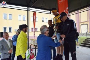 Na zdjęciach widzimy policjantów, którzy wzięli udział w wyścigu rowerowym, oraz ceremonię wręczenia medali dla zwycięzców.