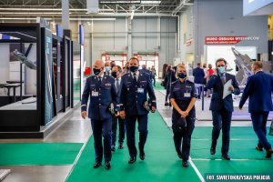 Komendant Główny Policji i jego Zastępca w towarzystwie Zastępcy Komendanta Wojewódzkiego Policji w Kielcach mł. insp. dr Agaty Malasińskiej-Nagórny i innych mężczyzn przyglądają się prezentowanemu sprzętowi