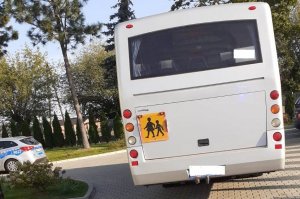 &amp;quot;autobus szkolny z tyłu na parkingu, po lewej stronie widać kawałek radiowozu oznakowanego&amp;quot;&amp;gt;