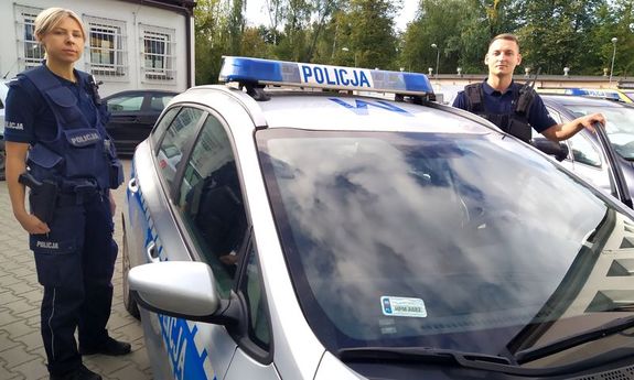 Policjanci którzy odnaleźli dziecko stoją przy radiowozie