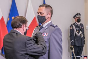 Minister Spraw Wewnętrznych i Administracji odznacza policjanta.