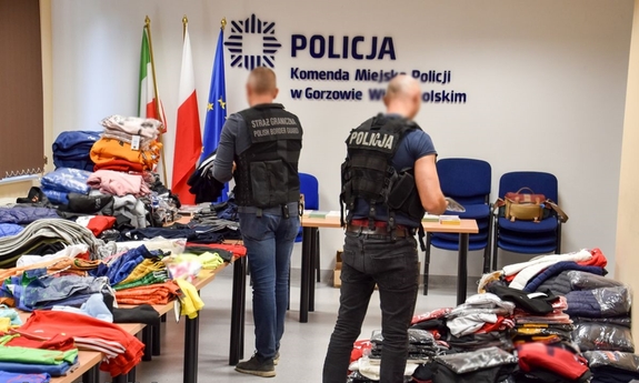 policjant i funkcjonariusz straży granicznej podczas oględzin zabezpieczonej odzieży