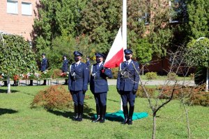 Policjanci zakładają Polską flagę na maszt