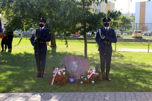 Policjanci stoją przy kamieniu upamiętniającym wywóz polaków na Syberie i do Kazachstanu