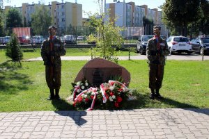 Mężczyźni ubrani w mundur stoją przy kamieniu upamiętniającym wywóz polaków na Syberię i do Kazachstanu