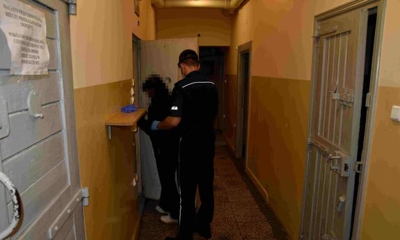 Zatrzymana kobieta prowadzona przez policjanta