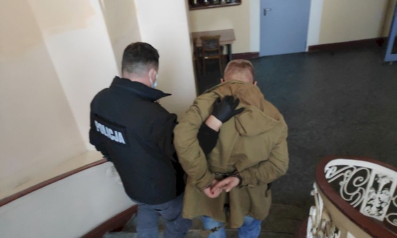 policjant prowadzi zatrzymanego mężczyznę