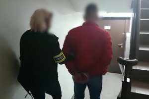 policjantka prowadzi zatrzymanego mężczyznę