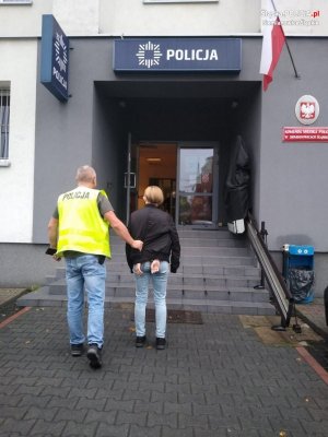 policjant idzie z zatrzymaną kobietą&quot;&gt;