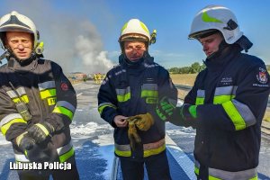 Trzej policjanci w strażackich ubraniach którzy brali udział w akcji gaśniczej na drodze S3