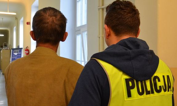 policjant prowadzi zatrzymanego mężczyznę