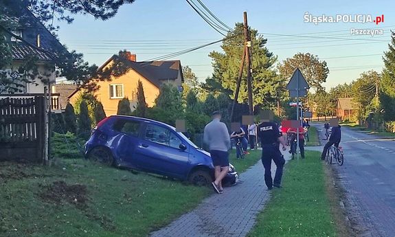 fotografia przedstawia niebieski samochód osobowy, który brał udział w zdarzeniu drogowym. Pojazd ten posiada uszkodzenia, znajduje się na skarpie, swoim przodem skierowany jest do jezdni