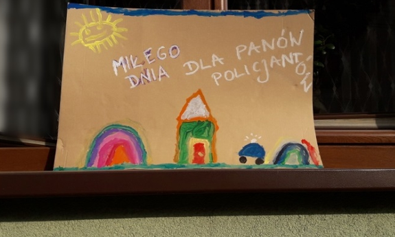 Wystawiony na parapet okna dziecięcy rysunek, na którym widnieje napis: &quot;MIŁEGO DNIA DLA PANÓW POLICJANTÓW&quot;