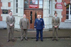 Dyrektor Regionalnej Dyrekcji Lasów Państwowych w Gdańsku - Bartłomiej Obajtek (pierwszy od prawej), pracowników Nadleśnictwa w Lubichowie - Rafał Apostołowicz (drugi od prawej), Komendant Wojewódzki Policji w Gdańsku nadinsp. Andrzej Łapiński (trzeci od prawej) i czwarty mężczyzna (czwarty od prawej) stoją przed Regionalną Dyrekcją Lasów Państwowych w Gdańsku