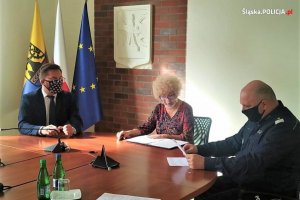 Komendant Wojewódzki Policji w Katowicach nadinsp. dr Krzysztof Justyński i Prezydent Miasta Katowice Marcin Krupa wraz z notariuszem czytają dokumenty