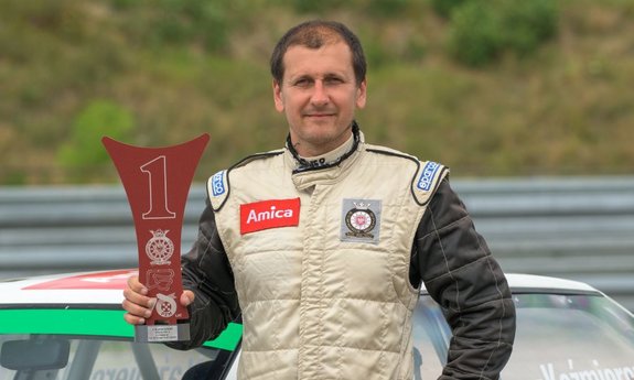 Asp. szt. Przemysław Kaźmierczak przed samochodem wyścigowym z nagrodą za pierwsze miejsce