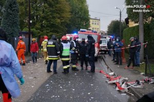 policjanci i strażacy stoją obok wozu strażackiego