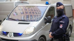 Policjant stoi przed radiowozem