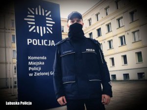 Umundurowany policjant przed budynkiem zielonogórskiej Policji