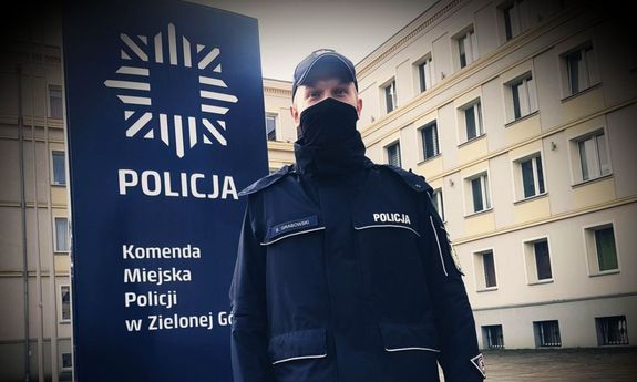 Umundurowany policjant przed budynkiem zielonogórskiej Policji