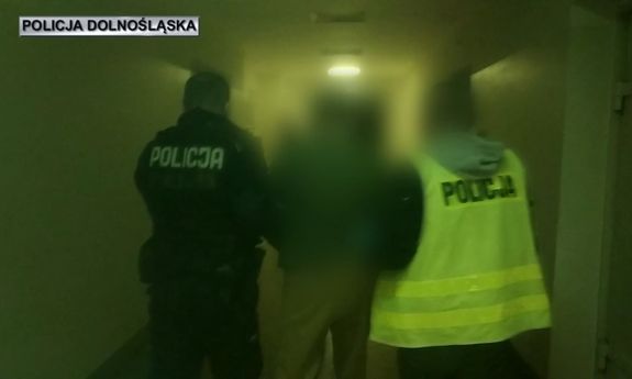 Policjanci prowadzą zatrzymanego