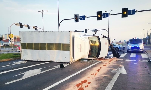 Na zdjęciu skrzyszowianie, sygnalizacja świetlna i samochód ciężarowy przewrócony na prawy bok leżący na pasach, obok dwa radiowozy policyjne