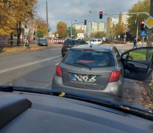 Zdjęcie szarej toyoty na skrzyżowaniu, zrobione z innego samochodu