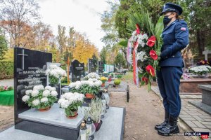 Cmentarz Powązkowski. Grób zamordowanego Komendanta Głównego Policji gen. Marka Papały. Przed grobem stoi policjantka z wieńcem.