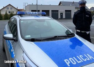 Policjant ruchu drogowego obok radiowozu