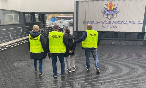 Policjanci prowadza zatrzymanego do Komendy