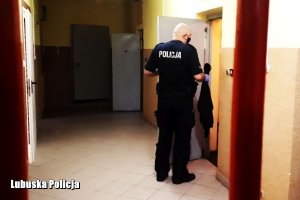 policjant zagląda do pomieszczenia dla osób zatrzymanych